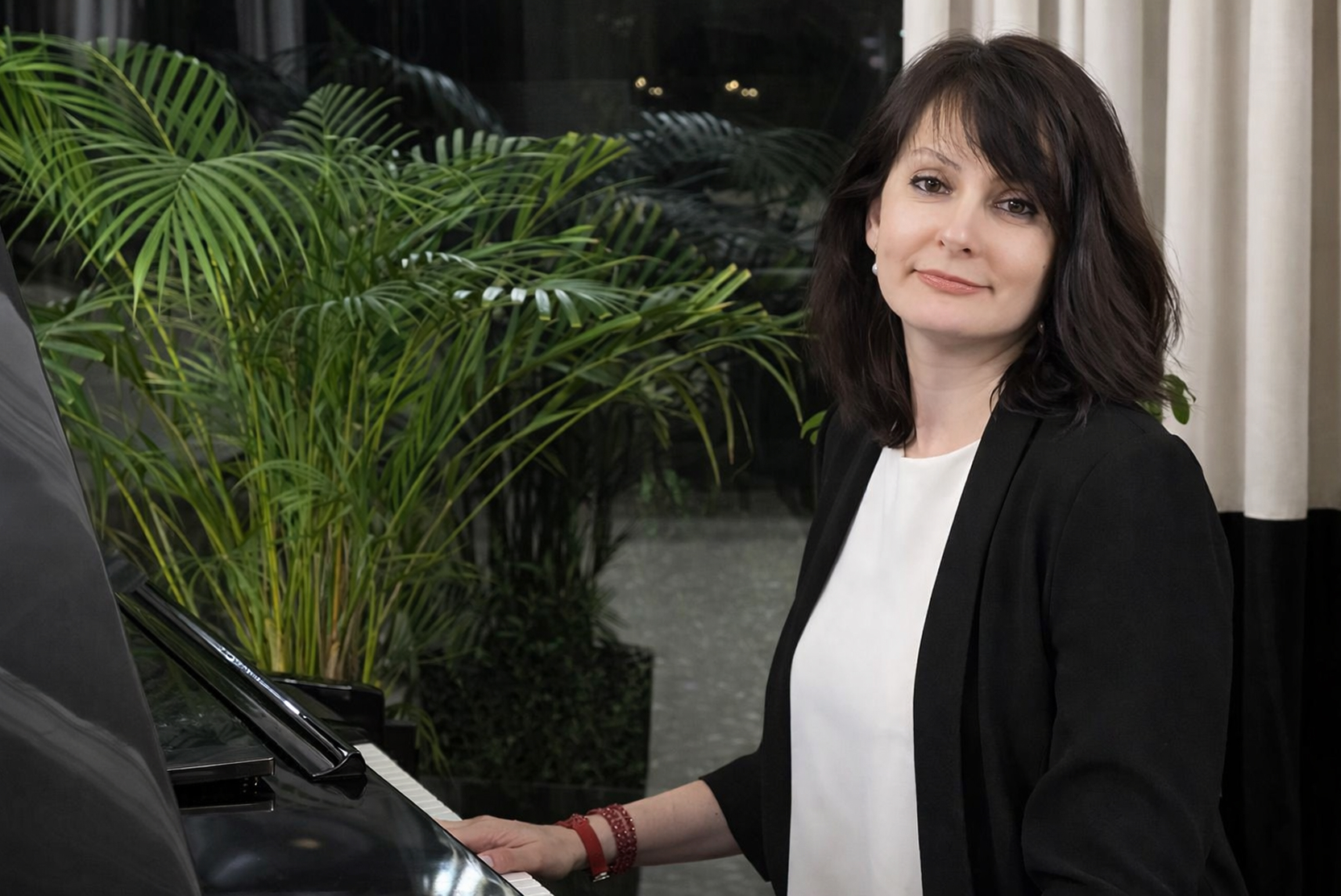 Mariia Malynovska standing near a piano